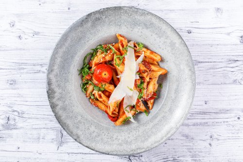 Bu çekimde penne makarnanın tüm güzelliklerini yakalamak için üstten bir açı tercih ettim. Doğal veya yumuşak bir yapay ışık kullanarak, makarnanın domates soslu parlaklığı ve rendelenmiş peynirin dokusunu vurguladım.Renkler gerçekten önemliydi. Domates sosunun canlı kırmızısı ve taze otların yeşili, beyaz ahşap arka plan üzerinde göze çarpıyor. Böylece, fotoğraftaki her detay, iştah açıcı ve estetik olarak hoş bir görünüm sunuyor.Kamera açısını hafif yukarıdan ve yakın çekim olarak ayarlayarak, tabağın tamamını ve içindeki malzemeleri net bir şekilde gösterebildim. Bu sayede, hem makarnanın hem de sosun detayları belirgin hale geldi.Fotoğrafçılıkta doğru ışık, renk ve açı kullanımı, yemeği hem lezzetli hem de görsel olarak çekici kılar. Fotoğrafın tamamında bu prensiplere sadık kaldım. İşte, yemeğin tüm büyüsü burada!